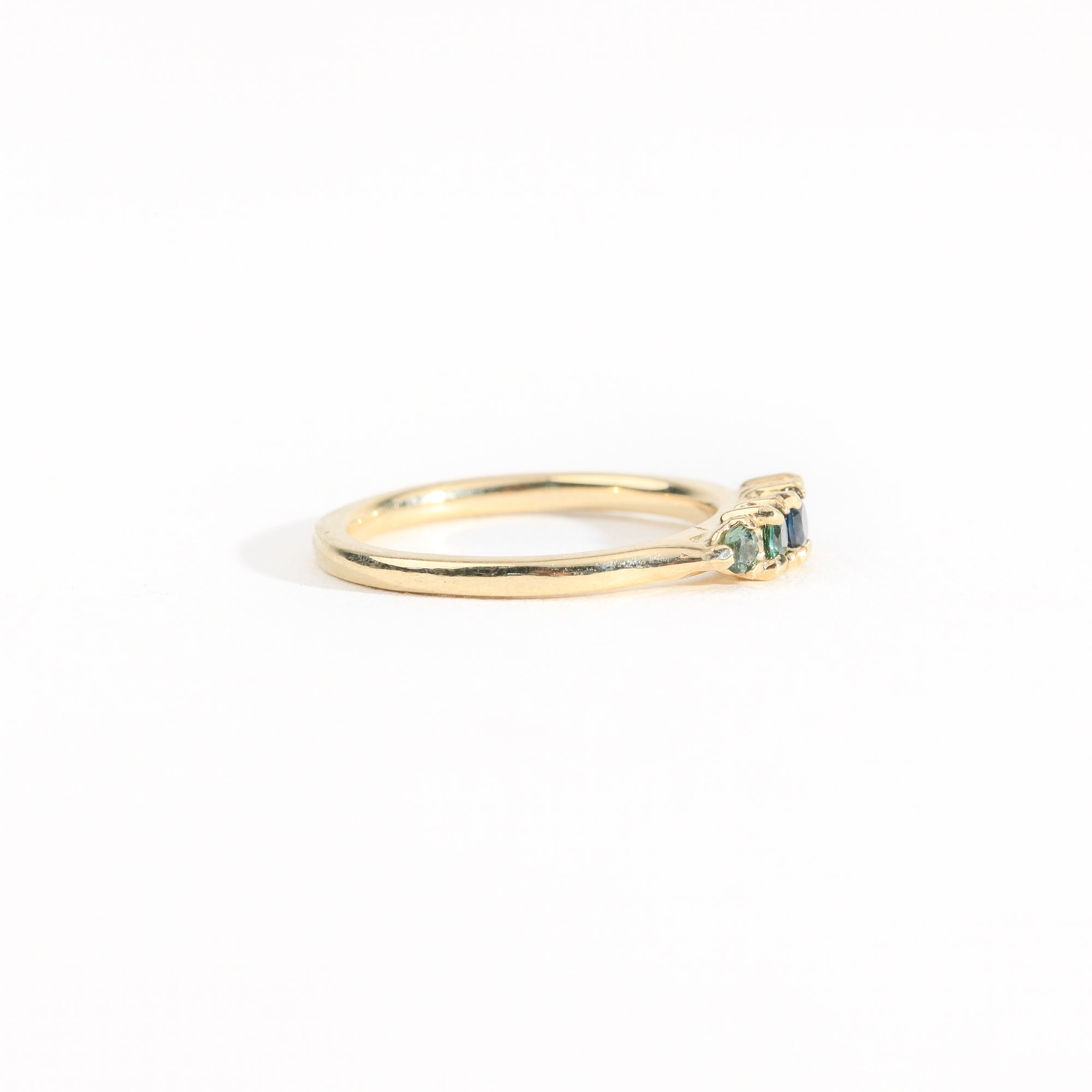 A bespoke handcrafted five stone ring in yellow gold with ethically sourced Australian teal sapphires