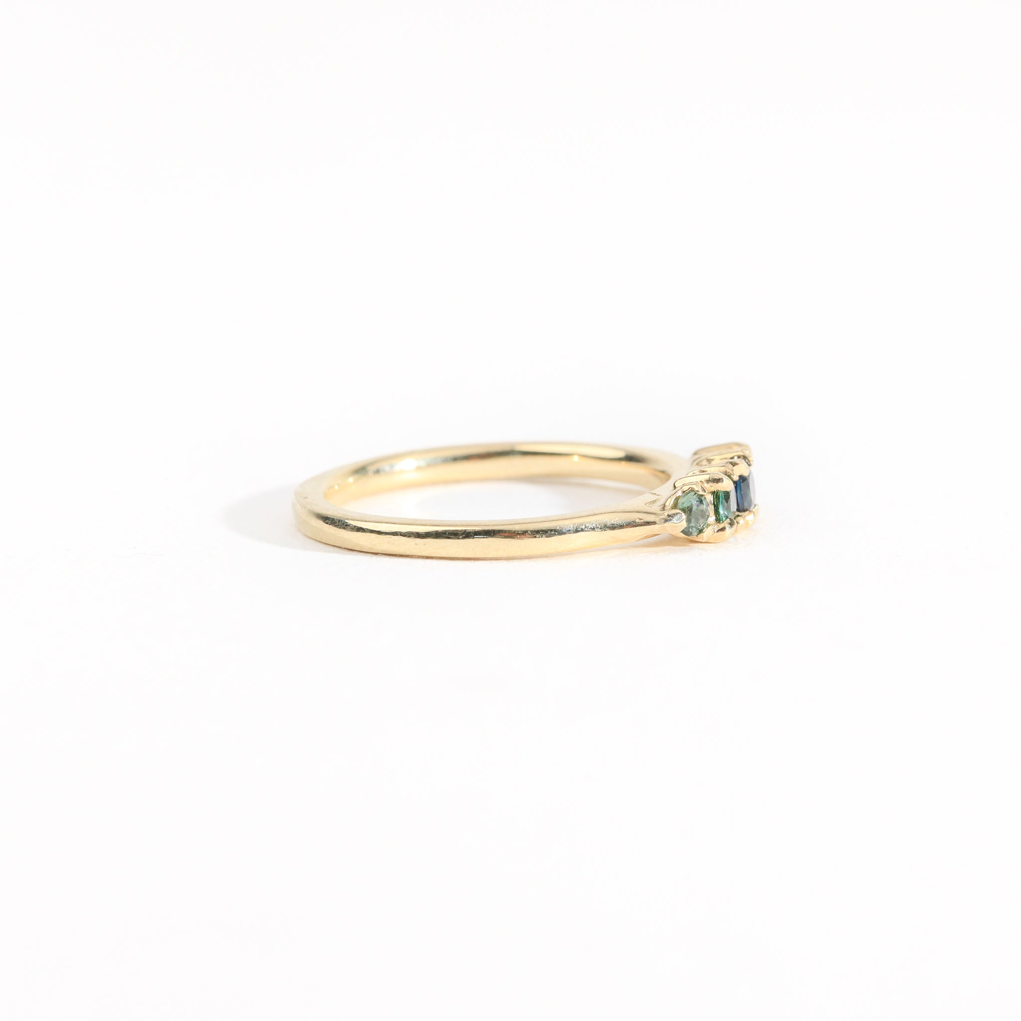 A bespoke handcrafted five stone ring in yellow gold with ethically sourced Australian teal sapphires