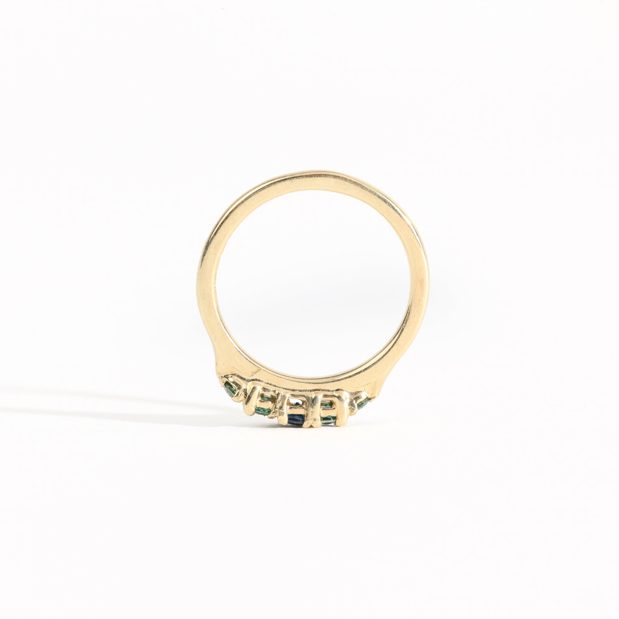 A bespoke handcrafted five stone ring in yellow gold with ethically sourced Australian teal sapphires