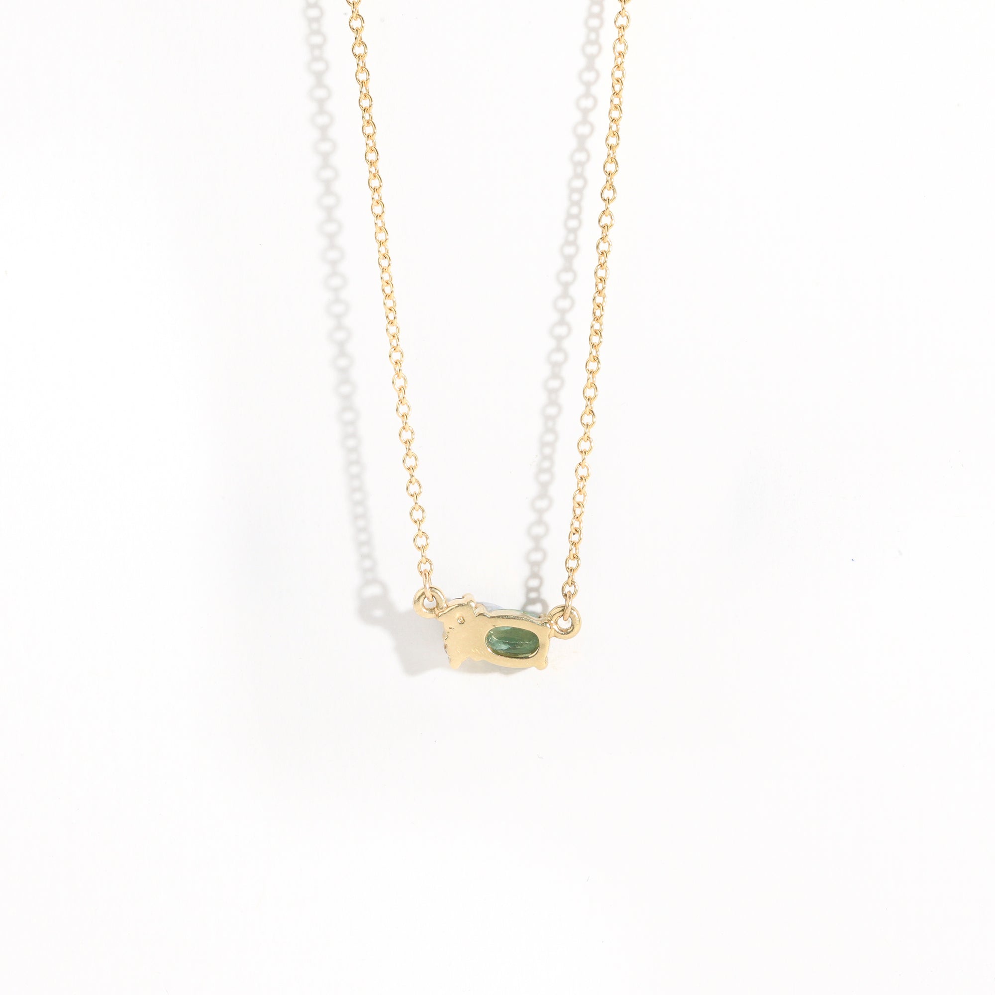 9 carat yellow gold three stone pendant, with a central green ethically sourced Australian sapphire, a deep blue round sapphire and a white diamond.