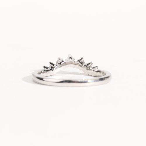 18 carat white gold woman's wedding band with 7 round white diamonds, claw set in a slight curve.