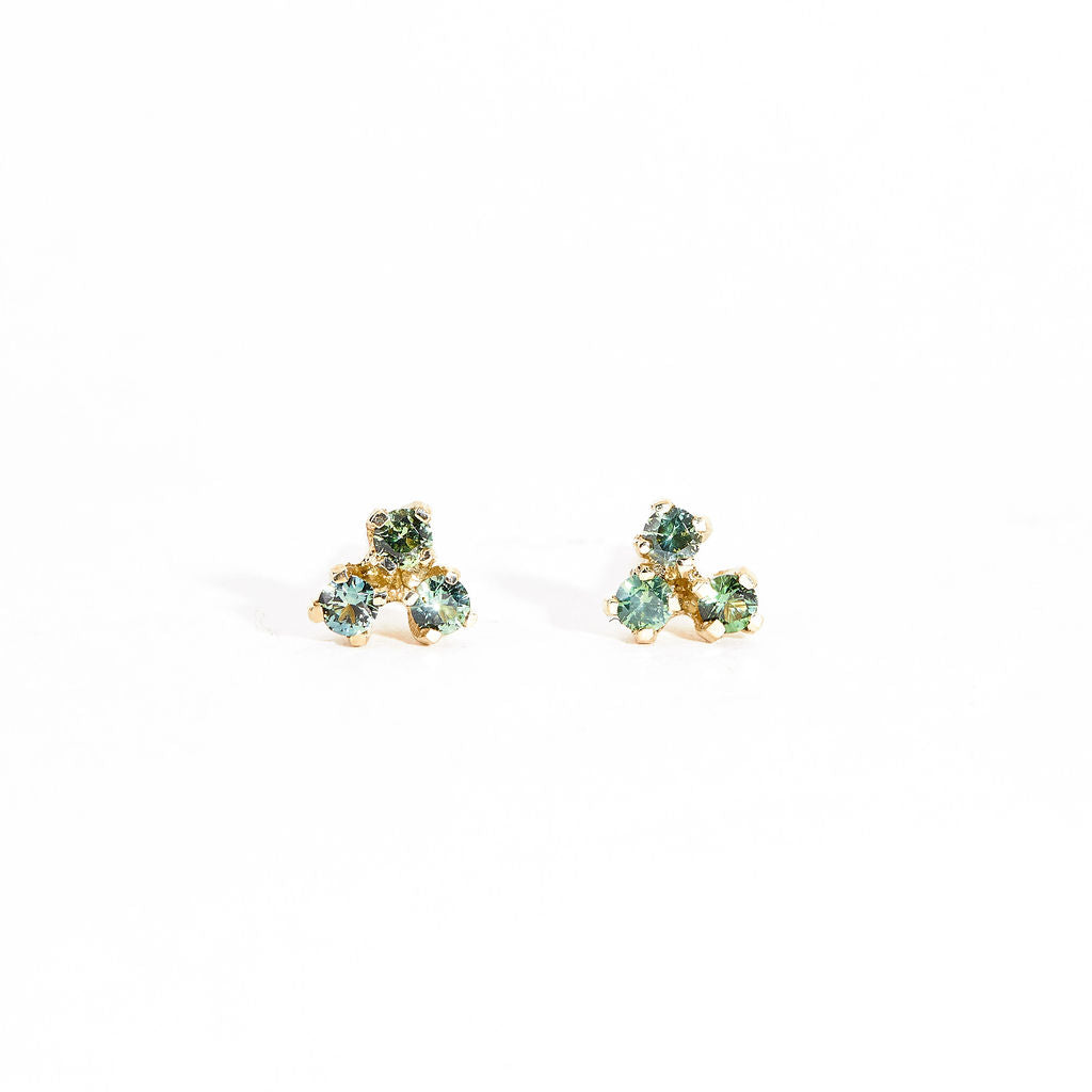 A pair of gold stud earrings featuring a mixture of blue, green ethically sourced Australian sapphires. Handmade in Melbourne by Black Finch Jewellery.