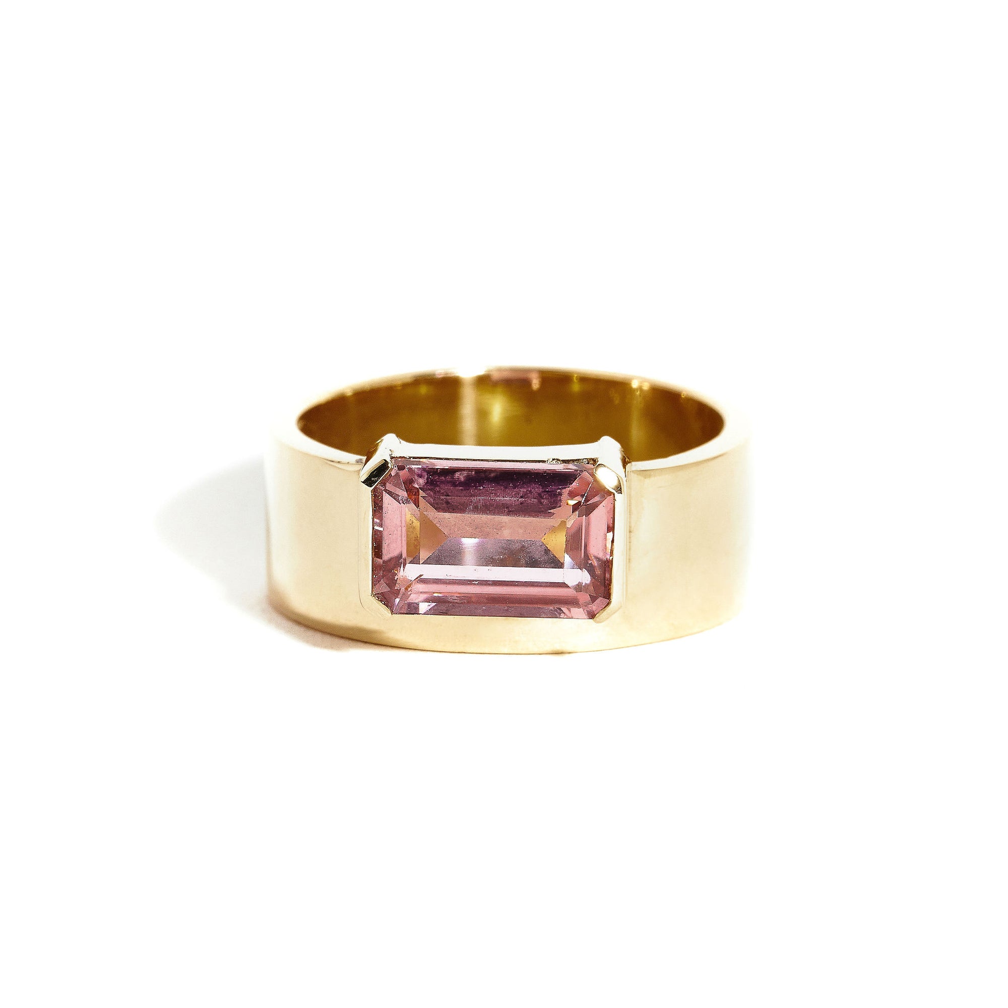  9 carat yellow gold, wide band ring, set with one emerald cut pink tourmaline. 