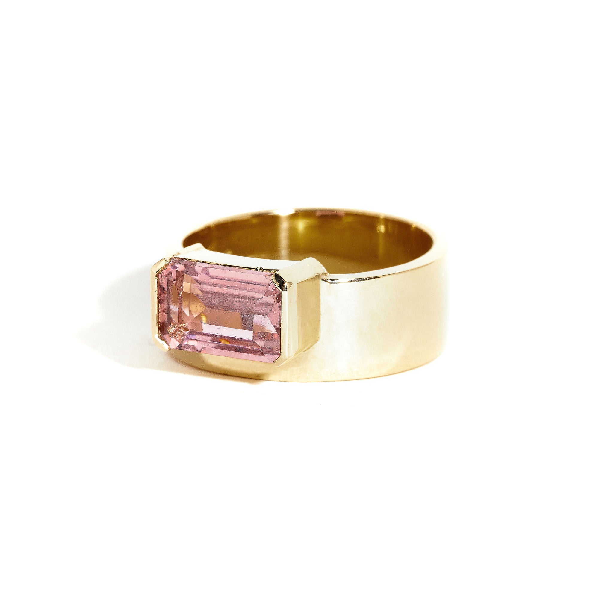  9 carat yellow gold, wide band ring, set with one emerald cut pink tourmaline. 