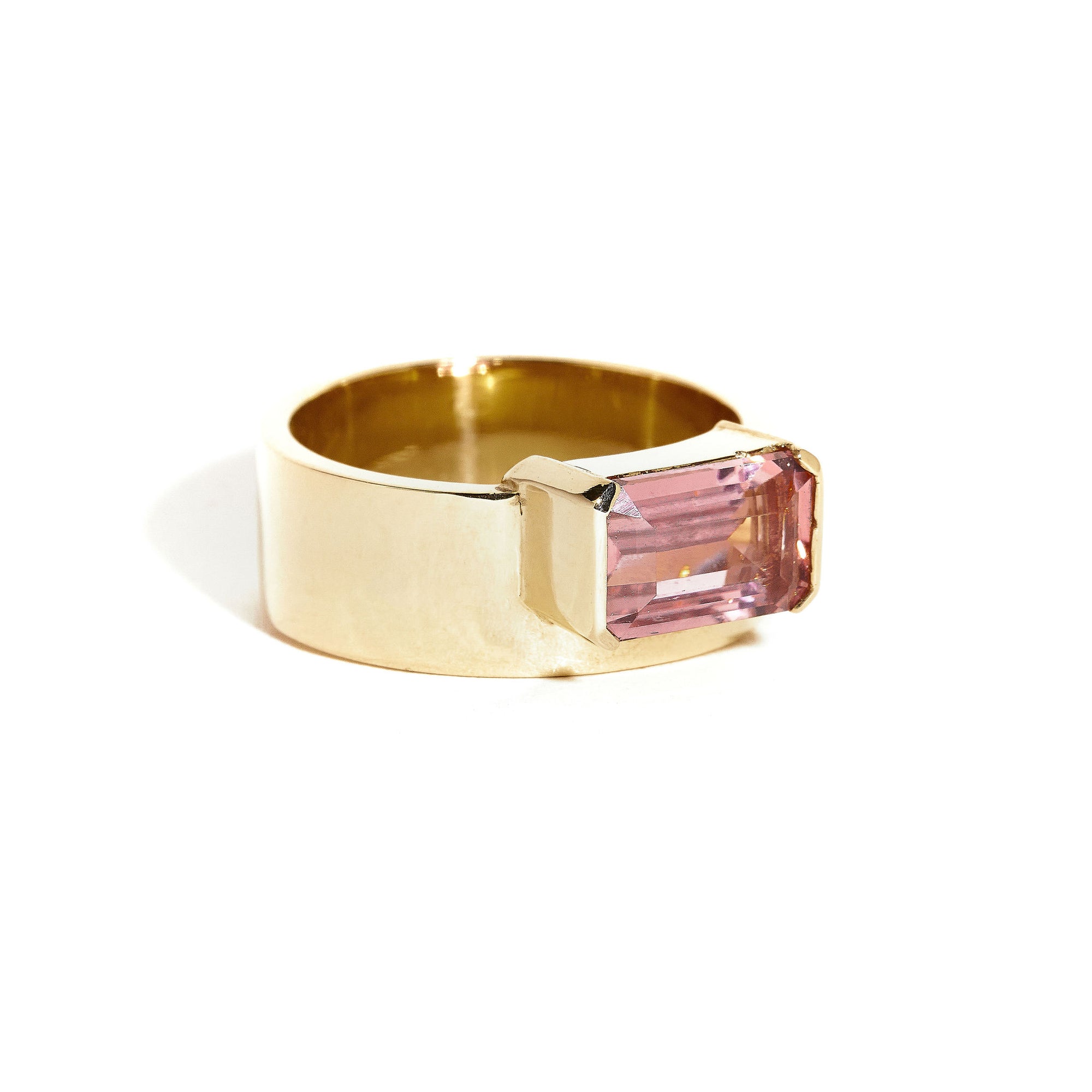  9 carat yellow gold, wide band ring, set with one emerald cut pink tourmaline. 
