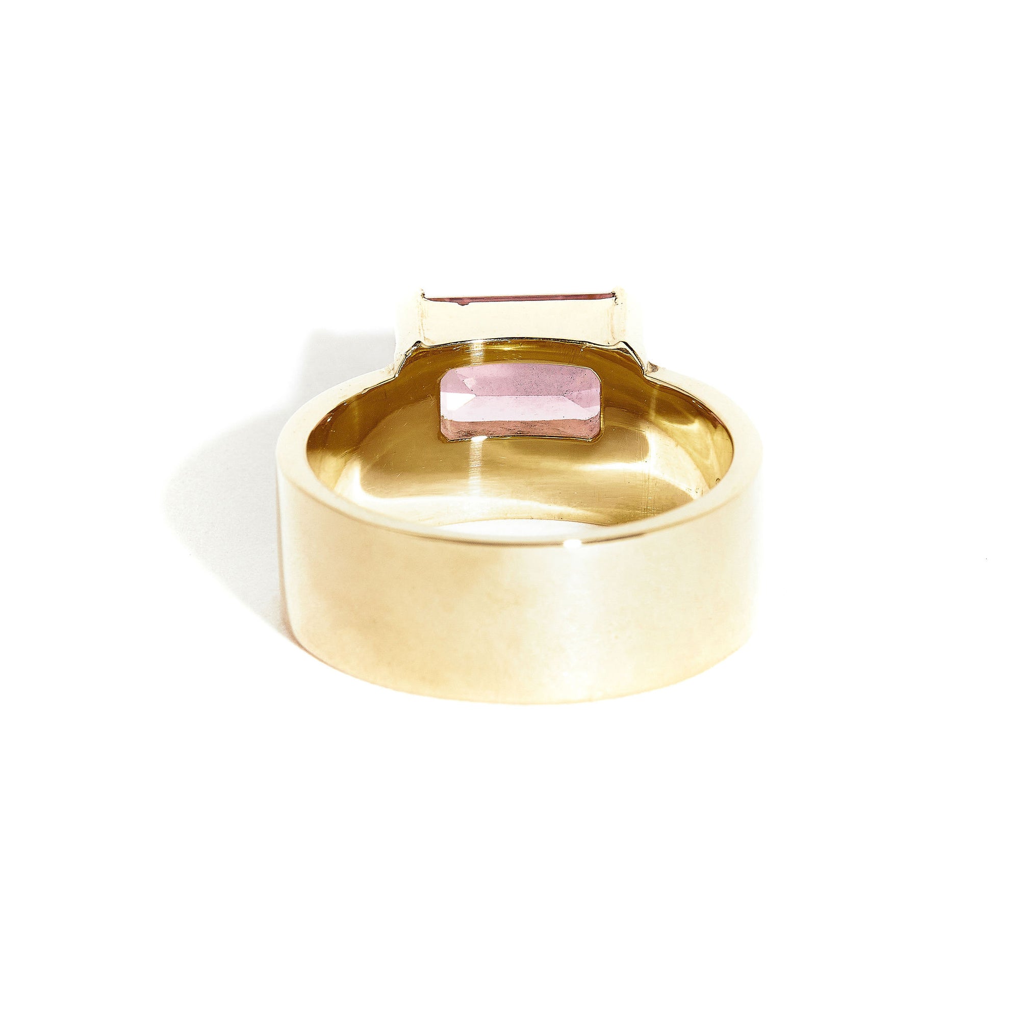  9 carat yellow gold, wide band ring, set with one emerald cut pink tourmaline. 
