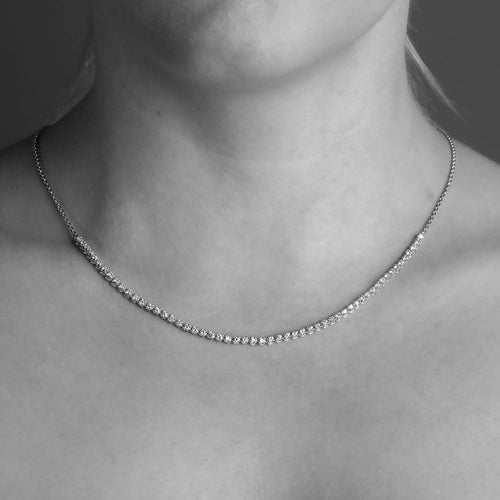  14 carat Yellow Gold tennis necklace with white diamonds worn around the neck