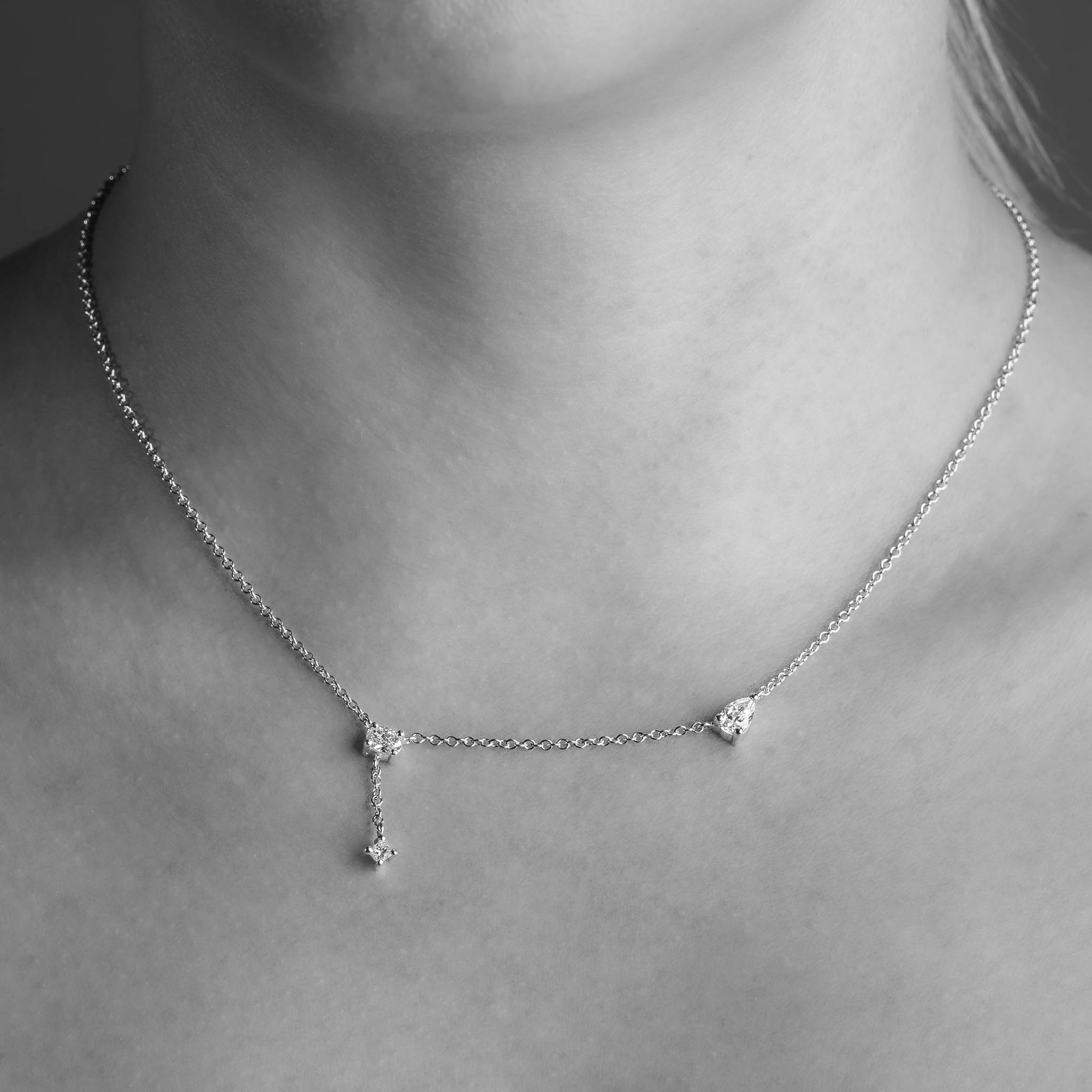 Three Stone Princess Cut, Oval Cut and Pear Cut White Diamond Necklace worn on the necj