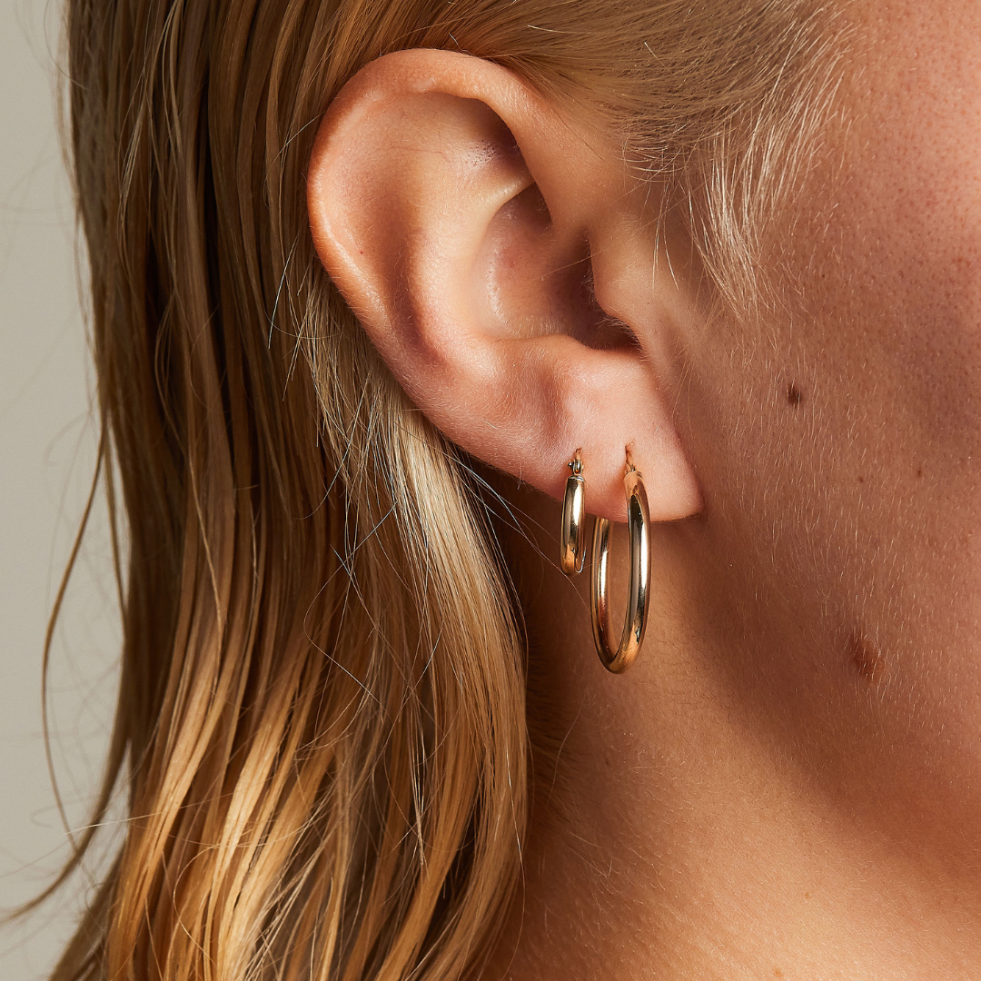 Classic 9 carat yellow gold small hoops, worn on a model with the classic 9 carat yellow gold medium hoops. 