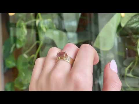  9 carat yellow gold, wide band ring, set with one emerald cut pink tourmaline, worn on the hand. 