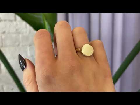 9 carat yellow gold round signet ring with a polished surface and soft matte band, worn on the hand. 